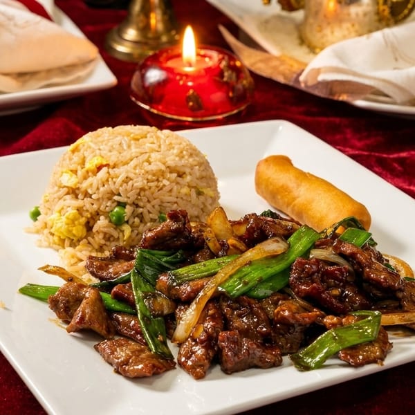 Beef and scallions with fried rice and an egg roll on a white plate, with a candlelit background.